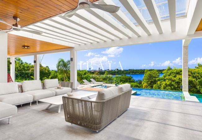 Salon d'extérieur avec piscine offrant une vue imprenable sur la mer - Villa haut de gamme aux Antilles