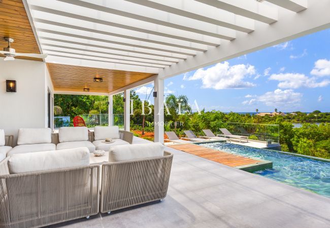 Salon d'extérieur 8 places avec piscine offrant une vue magnifique sur la mer - Villa haut de gamme aux Antilles