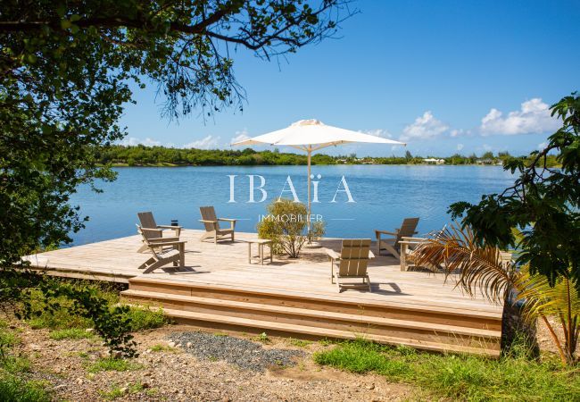 Deck en bois avec parasol et 6 fauteuils offrant une vue panoramique sur la mer - Villa haut de gamme aux Antilles