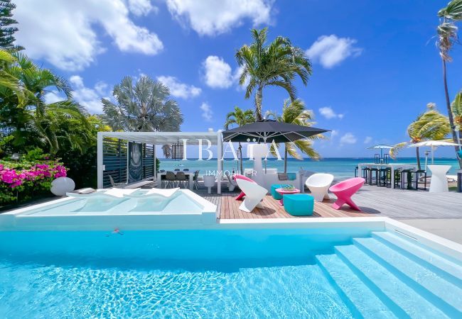 Piscine avec mobilier de jardin aux couleurs vives, pergola et table à manger offrant une vue sur mer, parasol et tables et chaises hautes - Villa hau