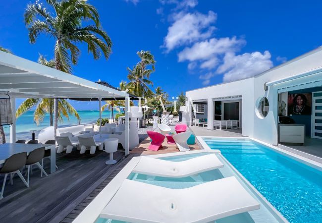 Transats dans la piscine, pergola avec salon d'extérieur et table à manger - Villa haut de gamme aux Antilles