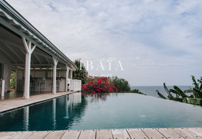 Vue magnifique de la piscine à débordement en bord de terrasse, offrant une vue panoramique sur l'océan, dans une villa de luxe aux Antilles