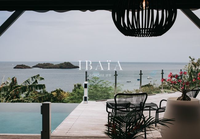 Vue imprenable depuis la terrasse et la piscine de la villa de luxe sur les îlets Pigeons, offrant un décor naturel exceptionnel aux Antilles