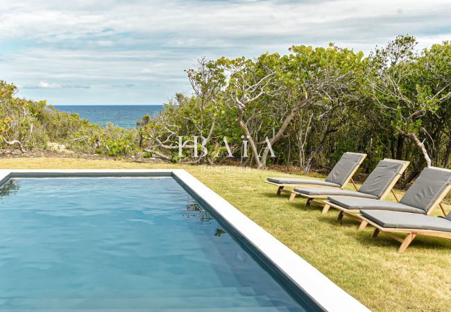 Vue sur l'océan et la piscine avec transats en bois à Marie Galante