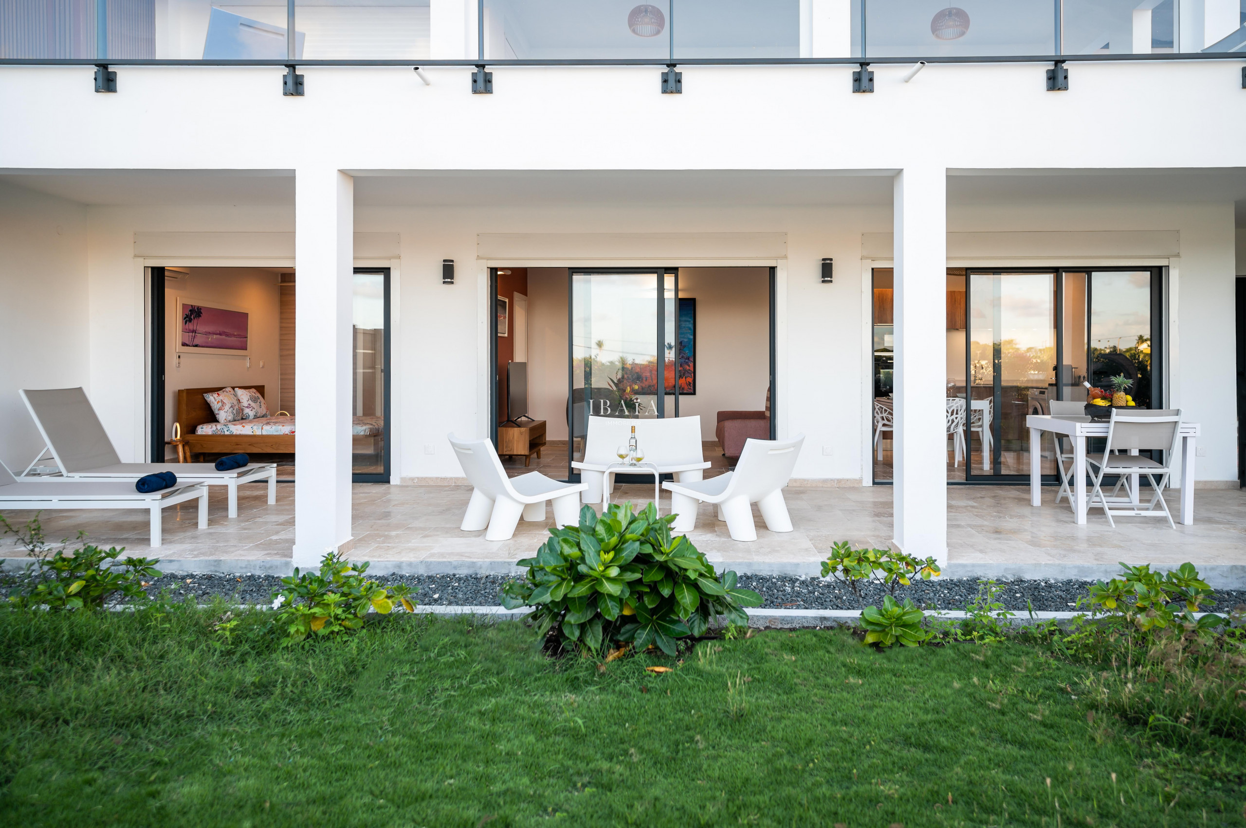 Façade extérieure d'une maison moderne avec des portes vitrées et un espace détente.