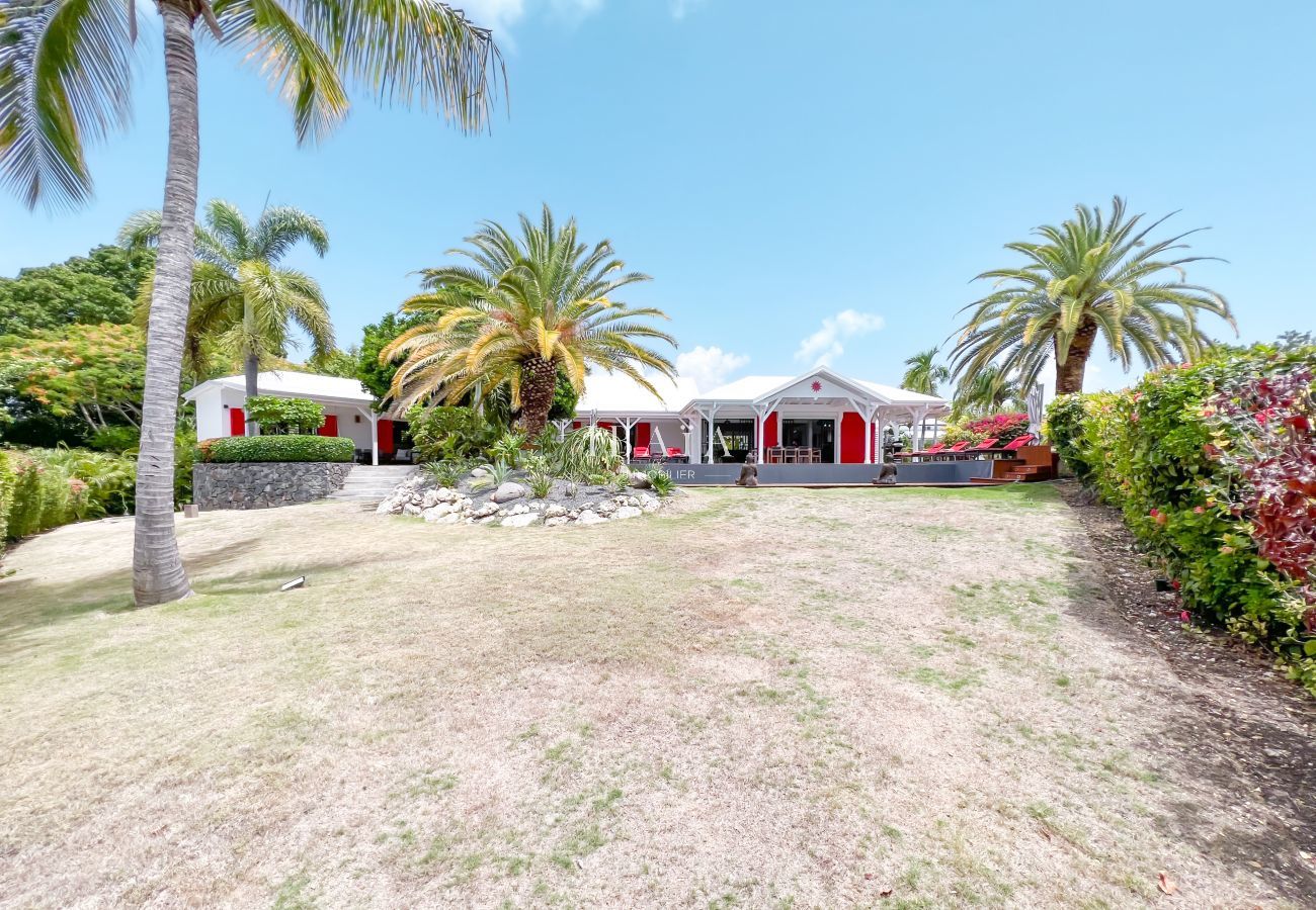 Vue du grand jardin tropical parfaitement entretenu entourant une villa haut de gamme aux Antilles