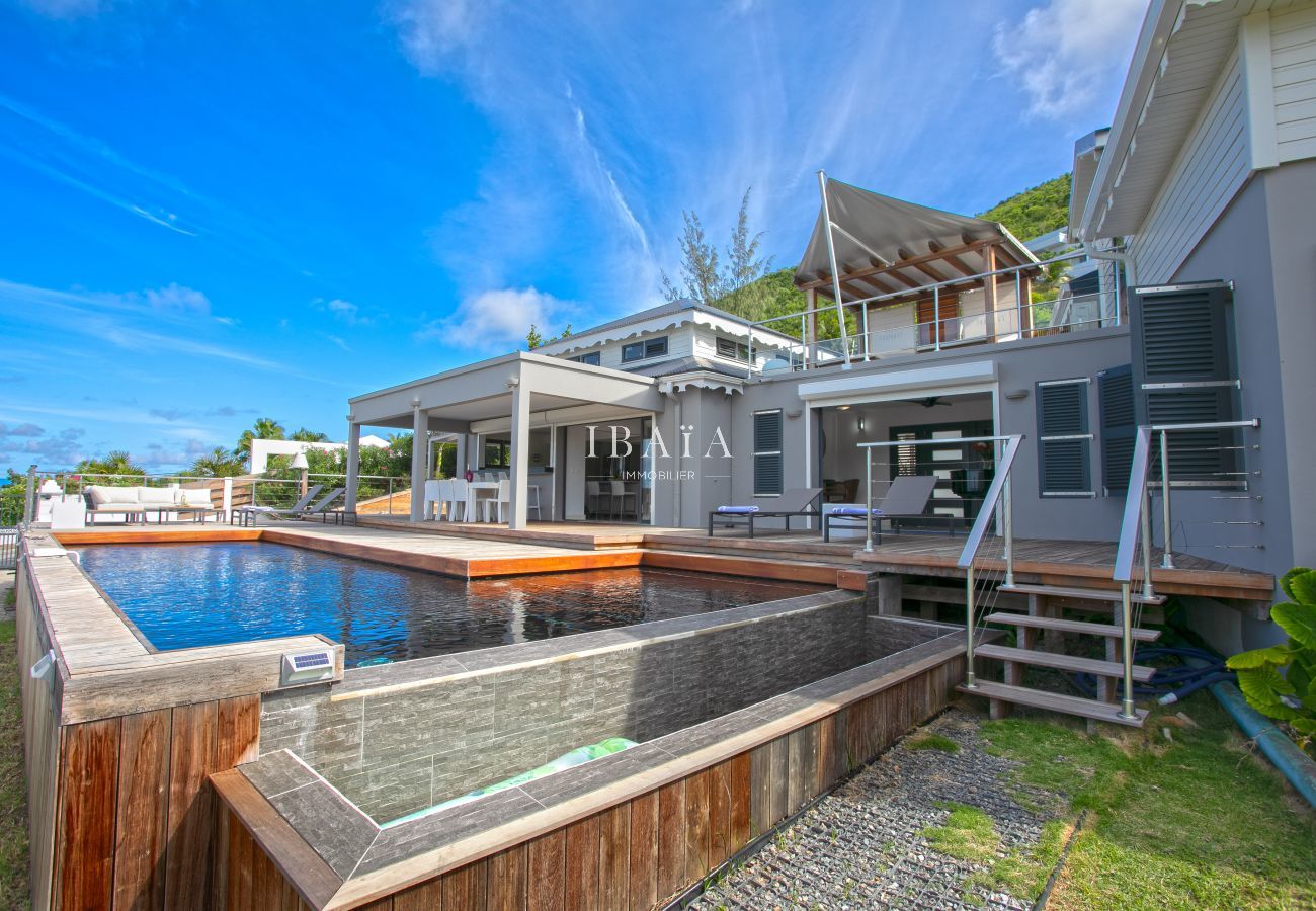 Piscine à débordement avec coffrage en bois et façade villa luxe