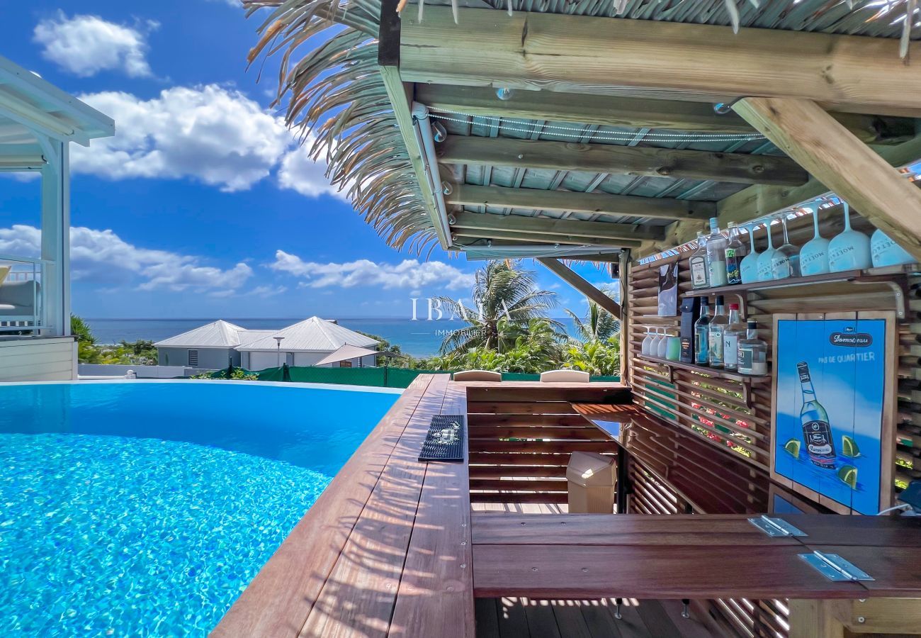 Paillote bois feuilles palmes bar terrasse piscine vue mer
