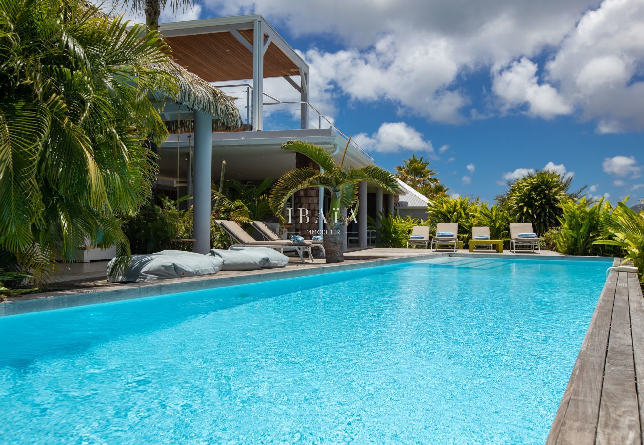 Vue sur la grande piscine rectangulaire avec transats dans notre villa haut de gamme aux Antilles