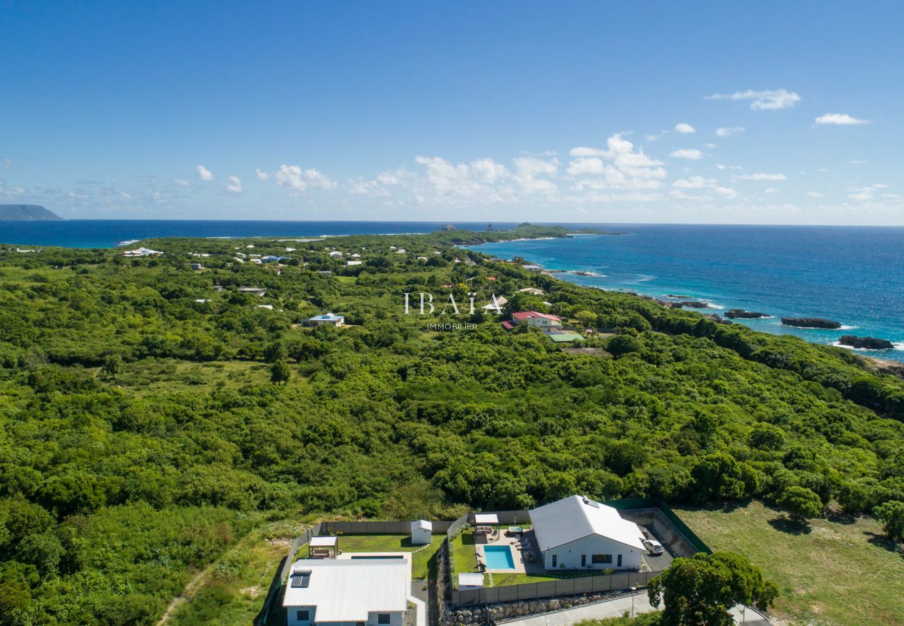  Vue aérienne exceptionnelle de la villa avec piscine, mer, Marie-Galante et végétation tropicale depuis la pointe des Châteaux, aux Antilles