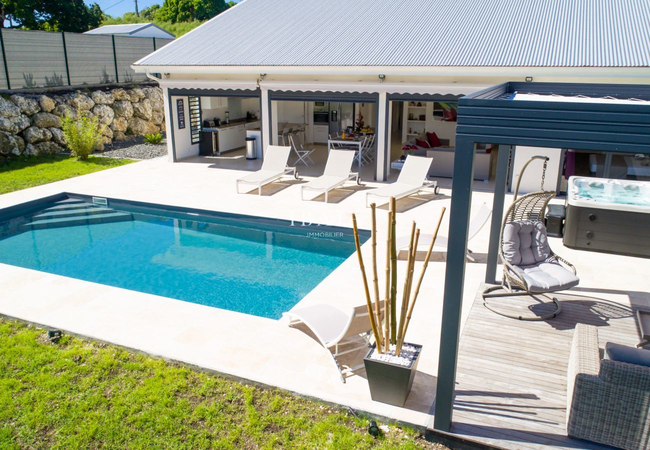 Vue enchanteresse de la piscine, terrasse, pergola et jacuzzi dans une villa haut de gamme aux Antilles