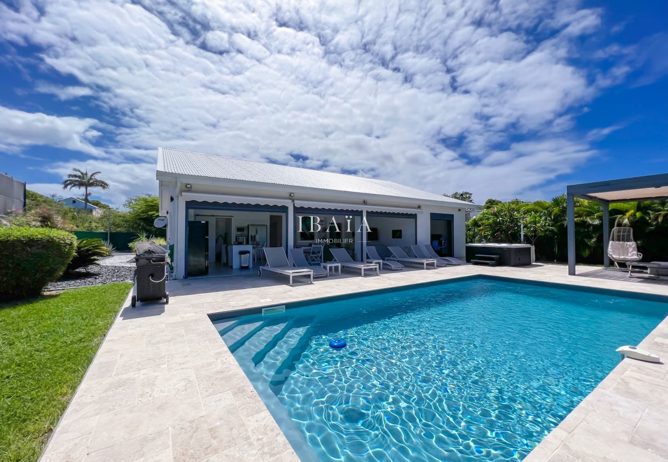 Vue captivante de la piscine, terrasse et pergola extérieure dans une villa haut de gamme aux Antilles