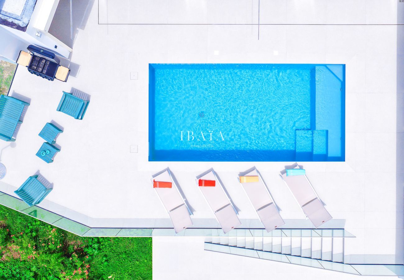 Piscine moderne vue du ciel avec transats colorés