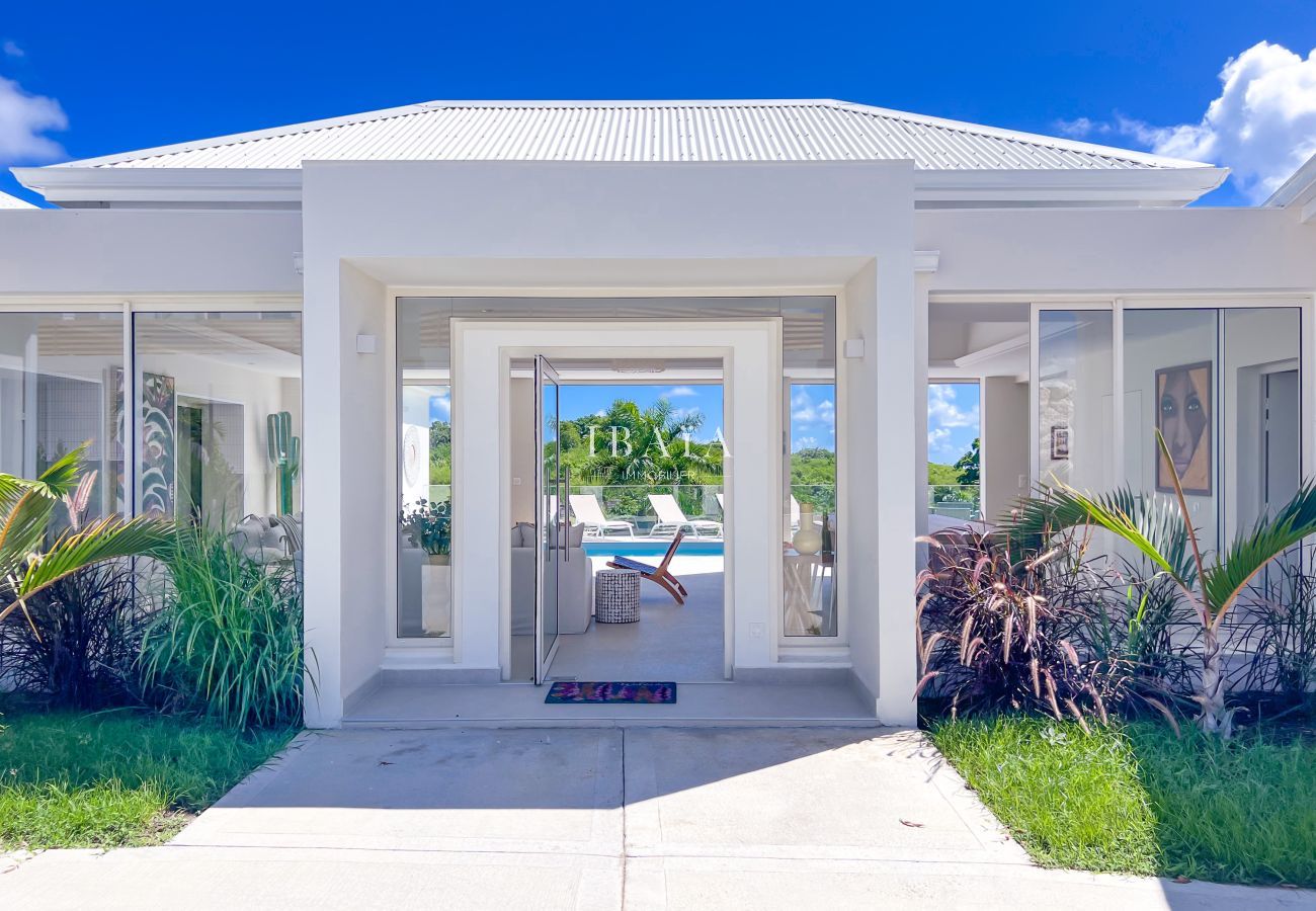 Façade moderne avec porte vitrée et piscine au fond