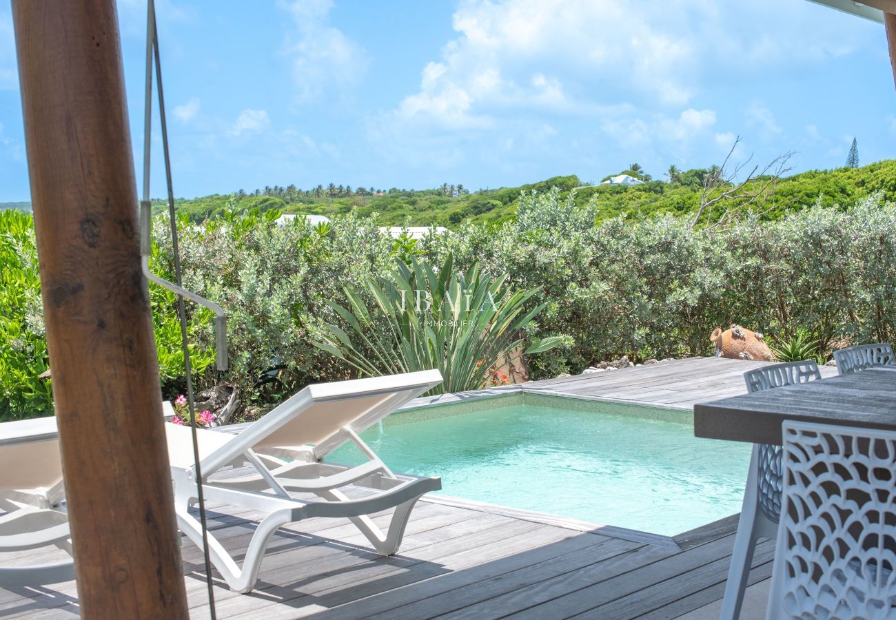 Transats au bord d’une petite piscine avec vue sur la nature